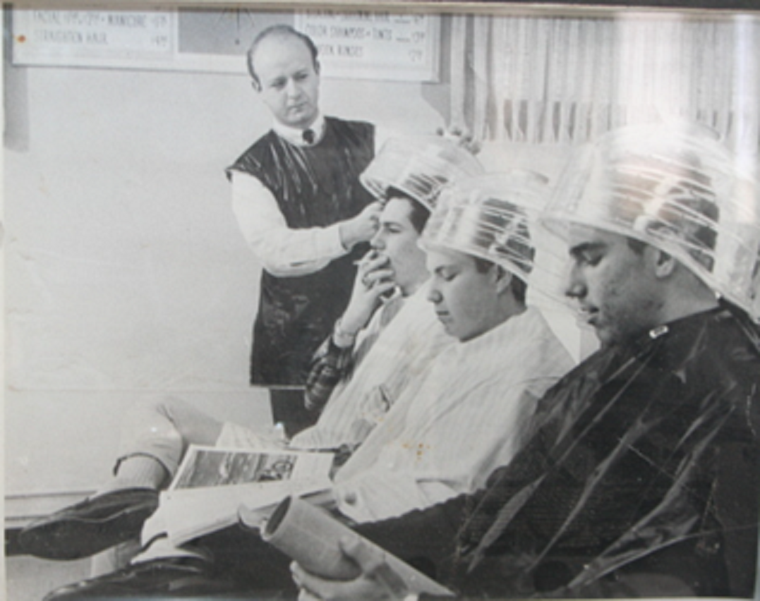 : A framed picture of men under hairdryers on display at the Salon and Spa Museum in Haltom City, Texas